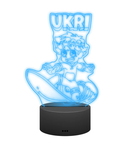 Ukri 3D LED Lampe in Cyan leuchtend: Ukri beim Surfen auf der Welle als Gravur auf der Acrylplatte mit schwarzem LED-Sockel – Creator-Merch von semukri.de