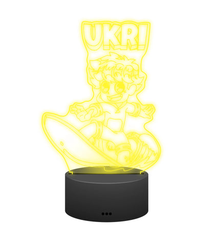Ukri 3D LED Lampe in Gelb leuchtend: Ukri beim Surfen auf der Welle als Gravur auf der Acrylplatte mit schwarzem LED-Sockel – Creator-Merch von semukri.de
